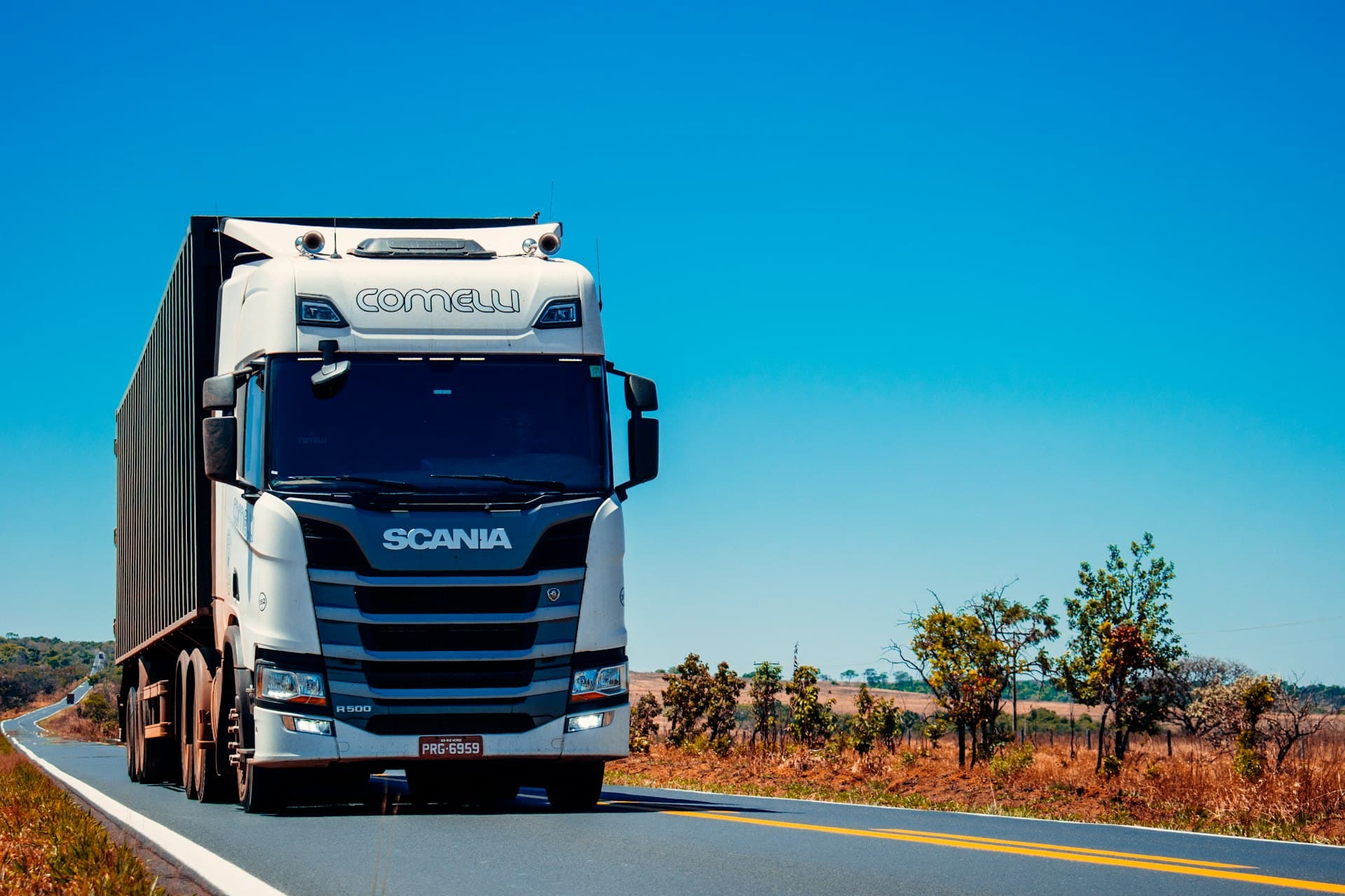 Heavy commercial freight truck loaded with cargo traveling along a multi-lane highway in India