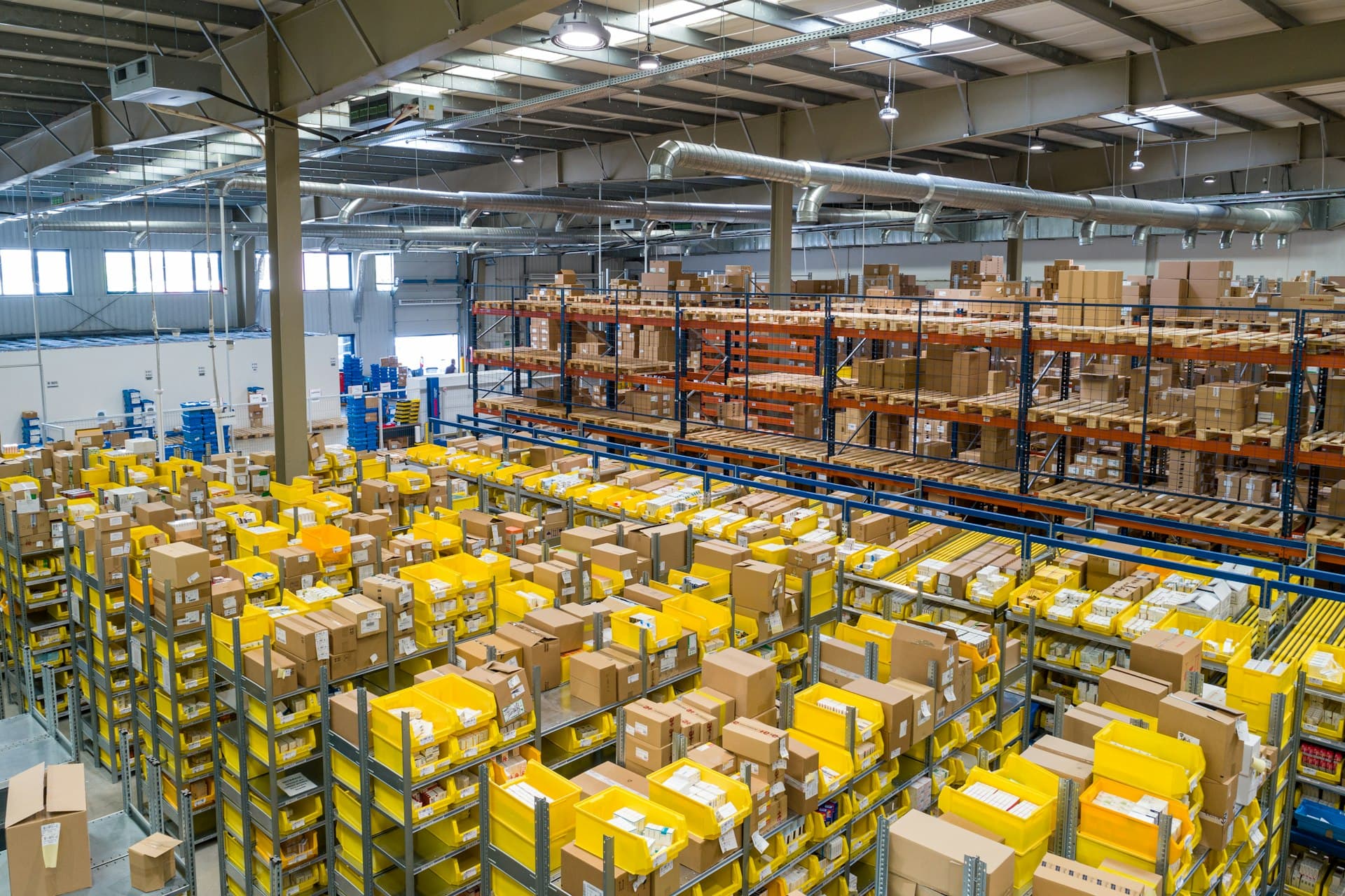 Modern industrial logistics warehouse with commercial trucks positioned at loading docks